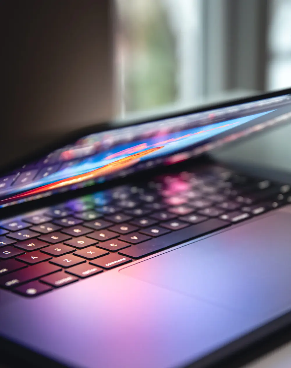 Ordinateur portable entrouvert au clavier éclairé par l’écran — maintenance de sites web à Verbier
