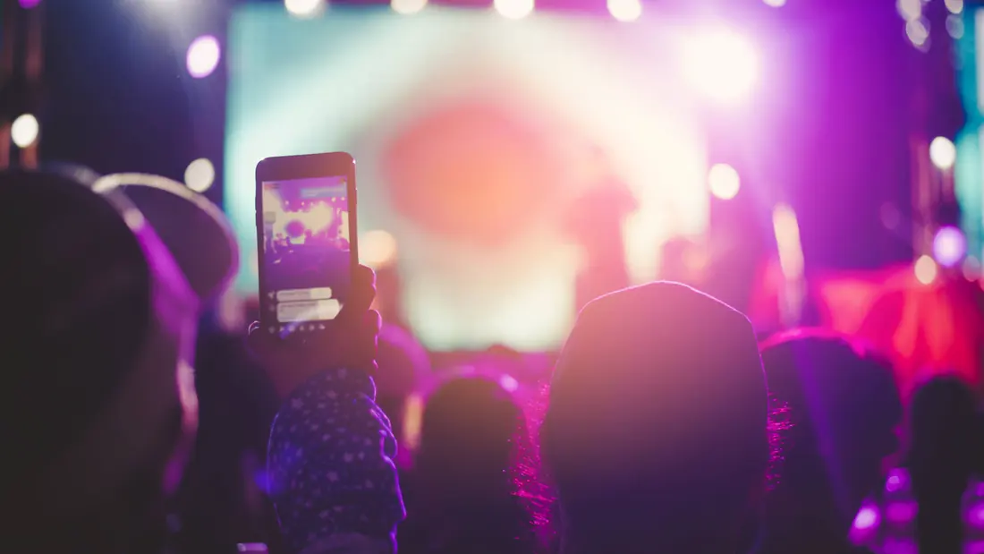Spectateur filmant un concert avec son smartphone